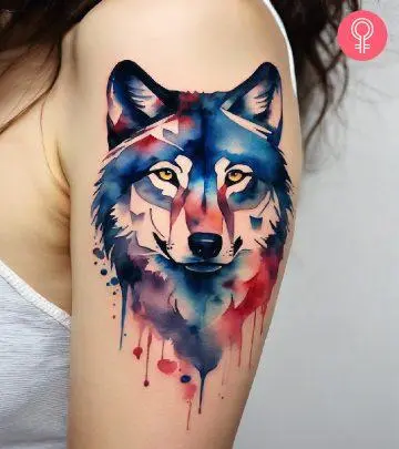 Wolf watercolor tattoo on the upper arm of a woman