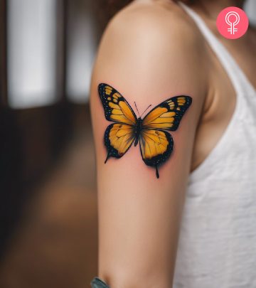 A woman with a red butterfly tattoo on her upper arm