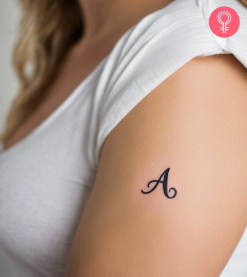 A woman wearing a ‘T’ style letter tattoo on the upper arm.