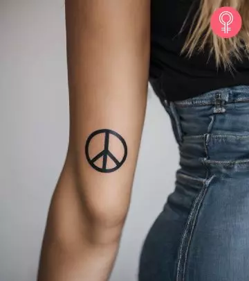 A woman with a Libra tattoo on her upper arm