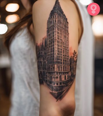 Liberty bell tattoo on the upper arm of a woman