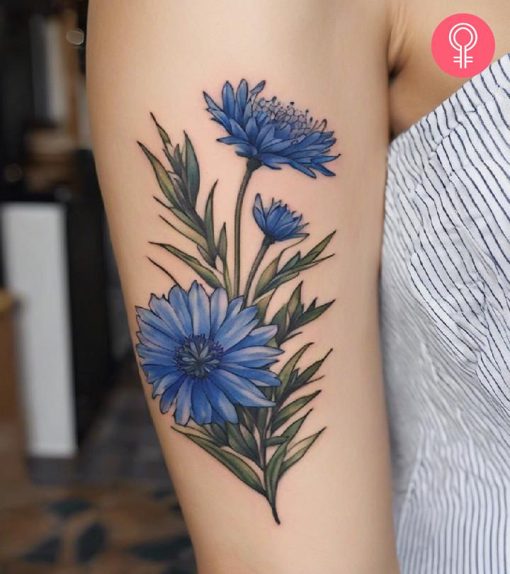 A cornflower tattoo on the upper arm