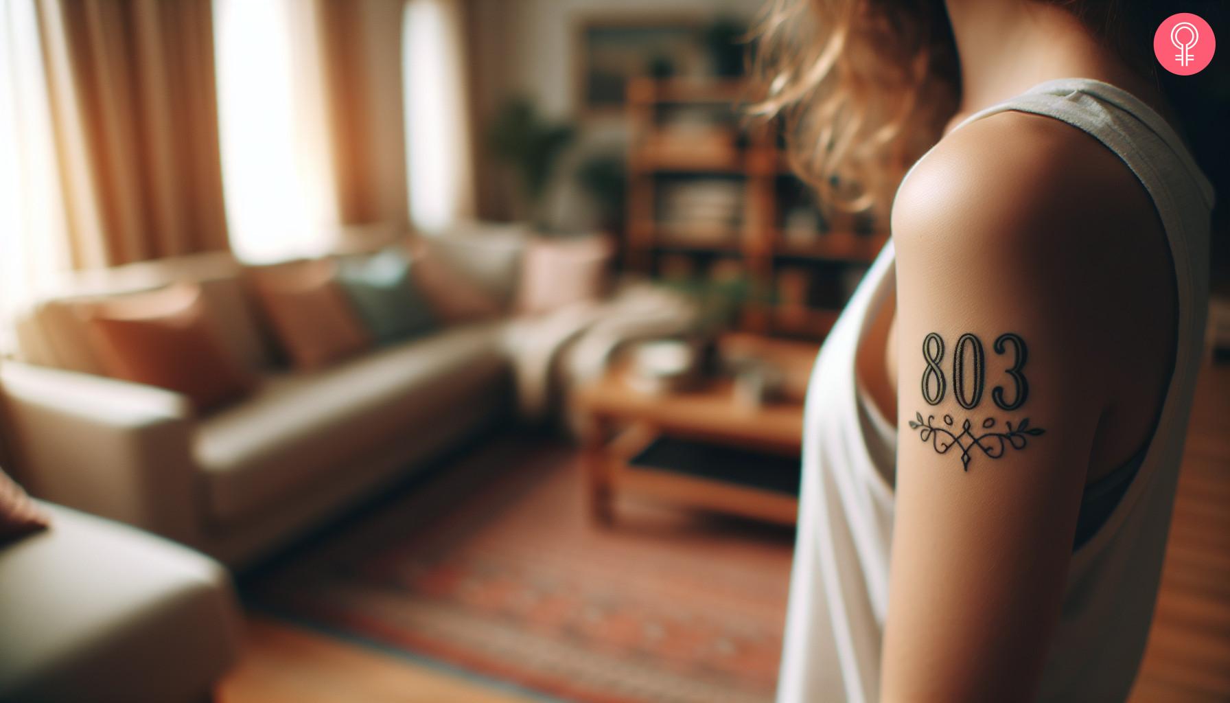 An 803 area code tattoo on the upper arm of a woman