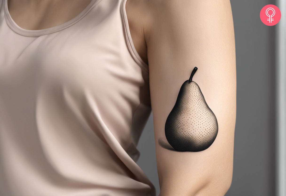 A 3D pear tattoo on a woman’s upper arm