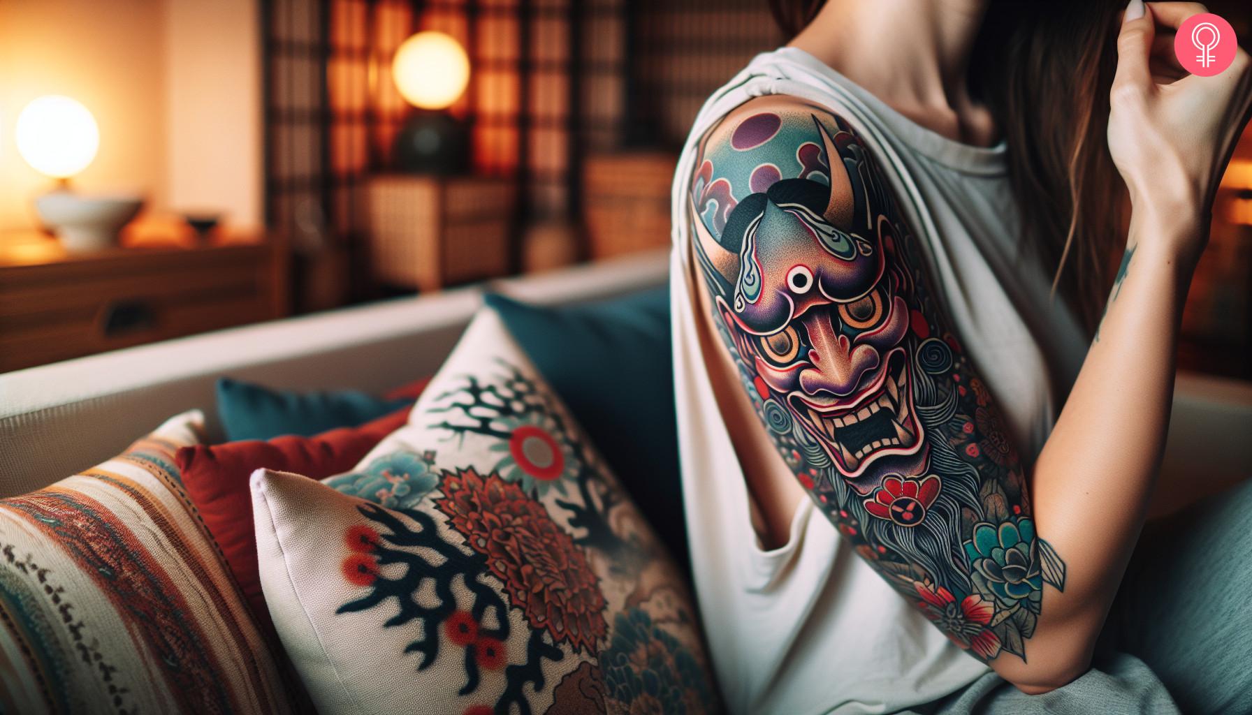 A Japanese Hannya mask tattoo on a woman's upper arm