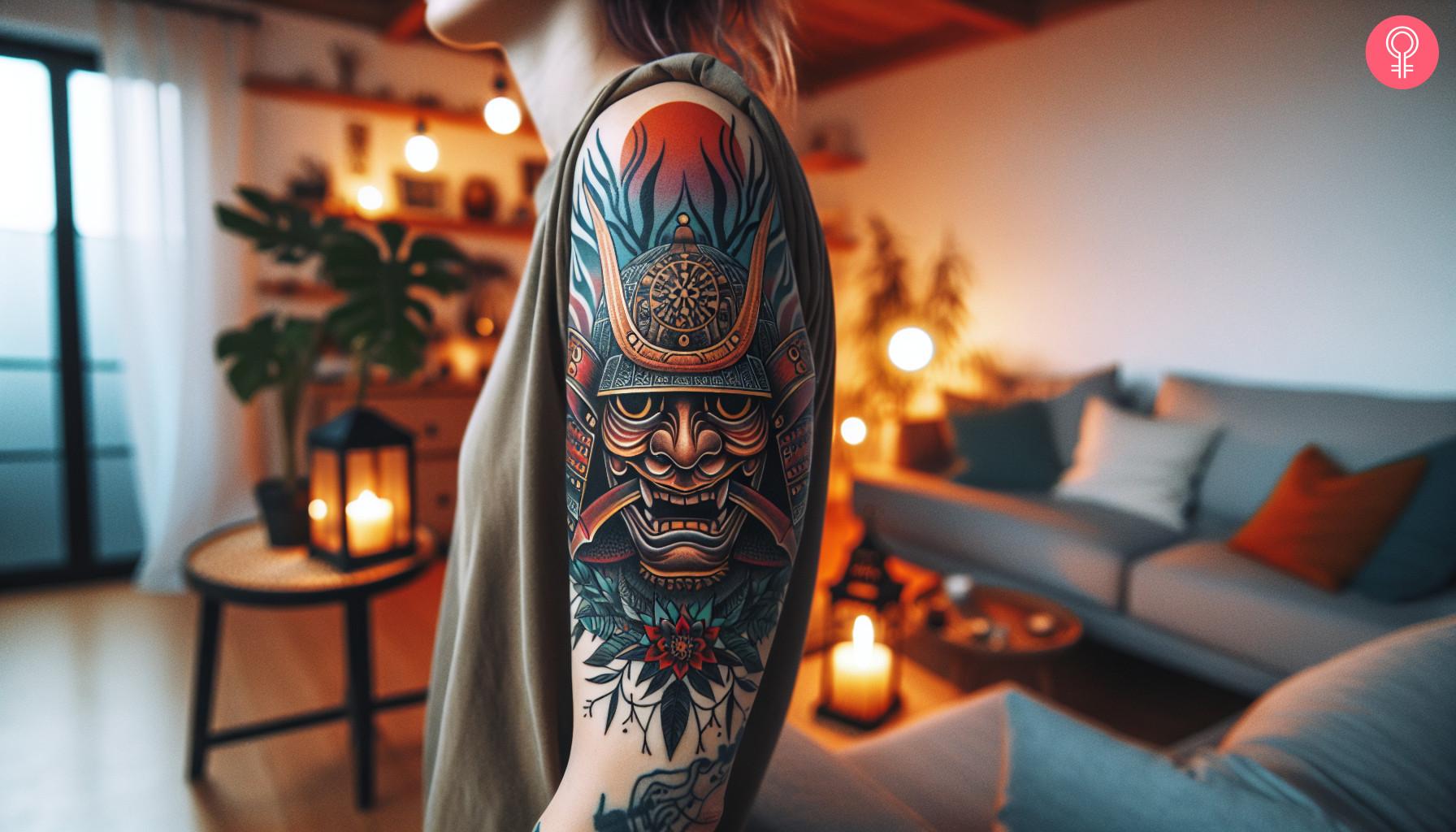 A Japanese samurai mask tattoo on a woman's upper arm