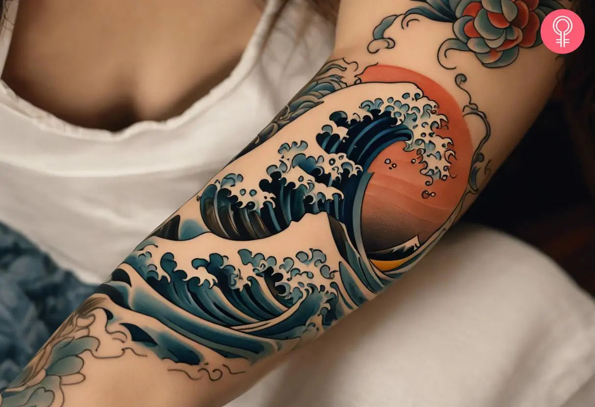 A Japanese wave tattoo on the forearm of a woman