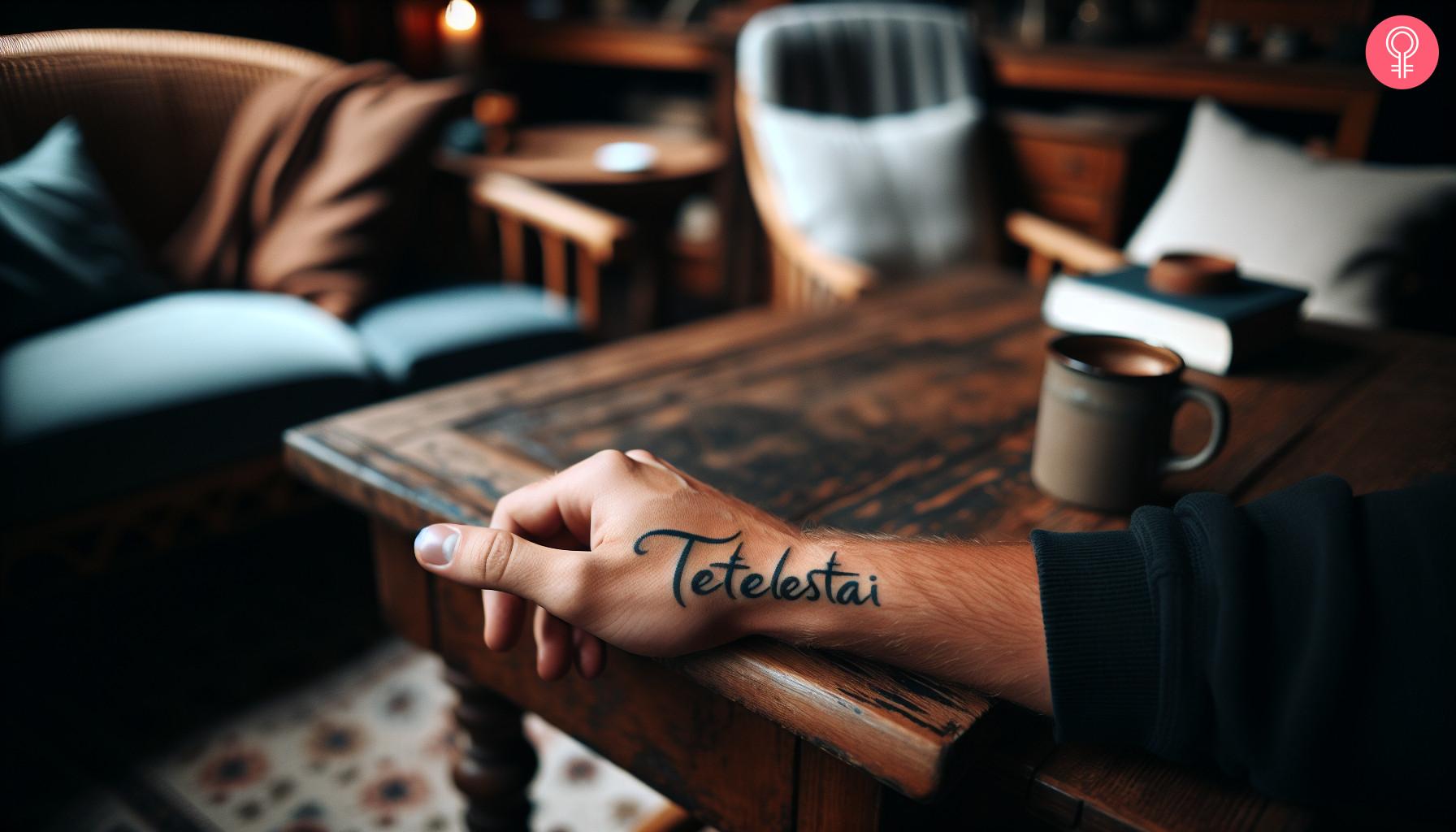 A Tetelestai tattoo on the side of a man's hand