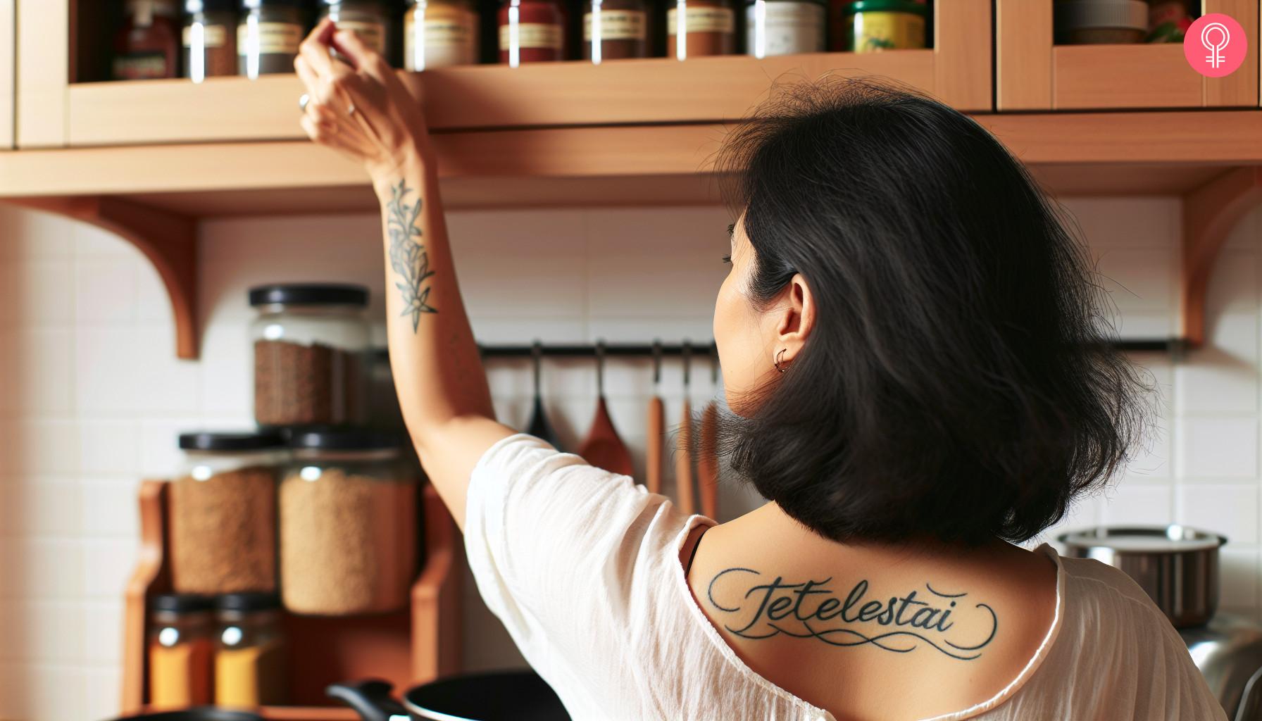 A Tetelestai tattoo on a woman's upper back