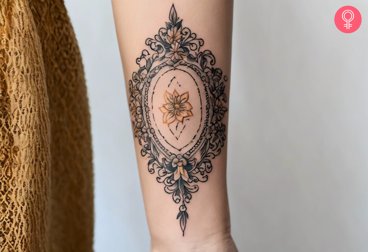 A baroque tattoo with a mirror frame on the forearm