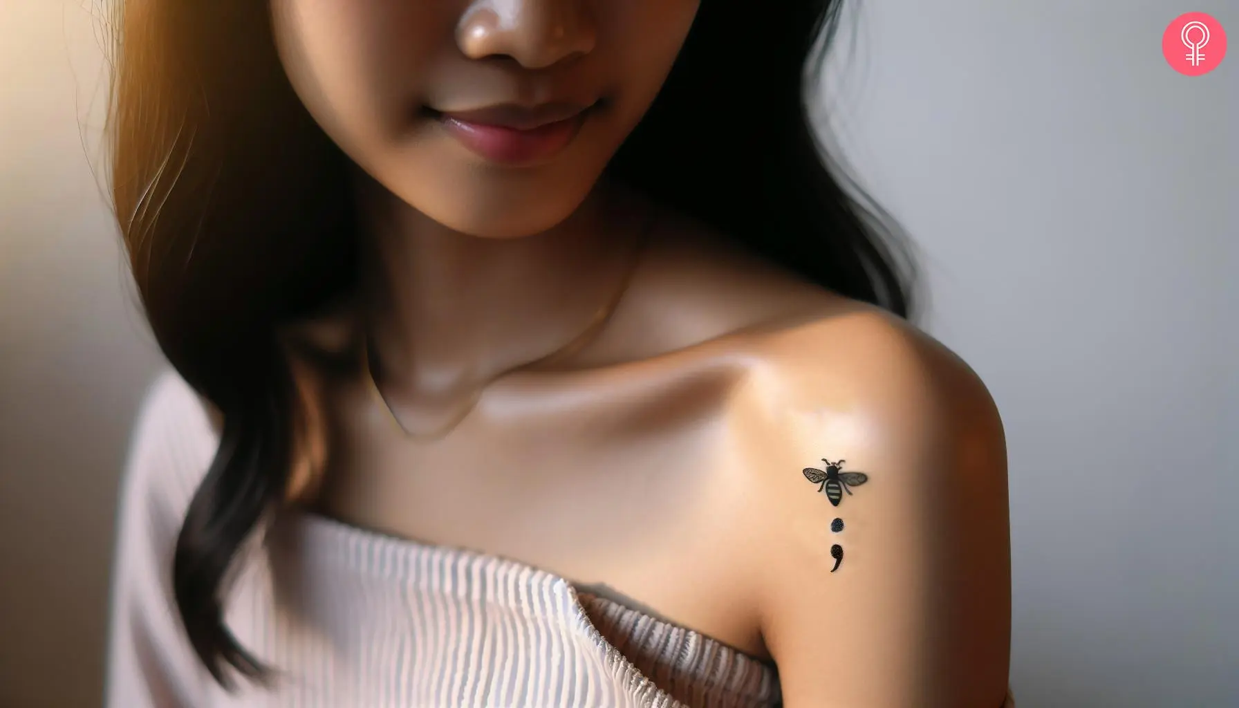 A bee and a semicolon tattoo on the shoulder