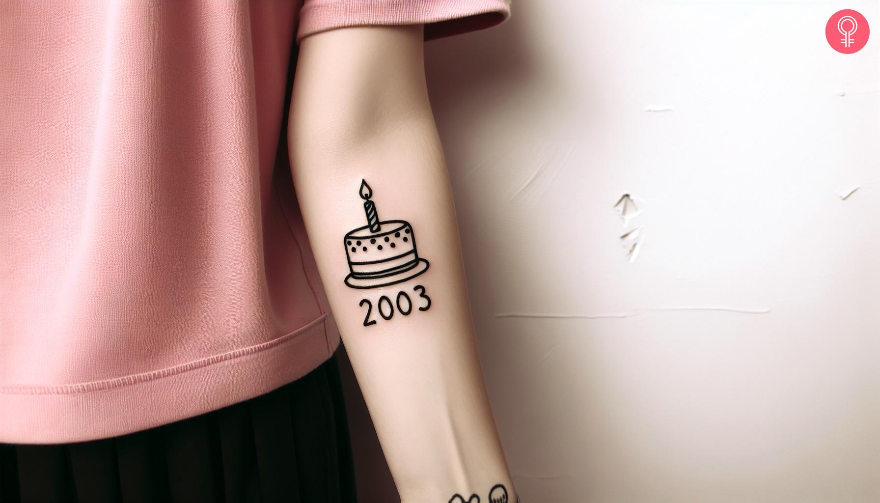 A birthday cake tattoo on the forearm