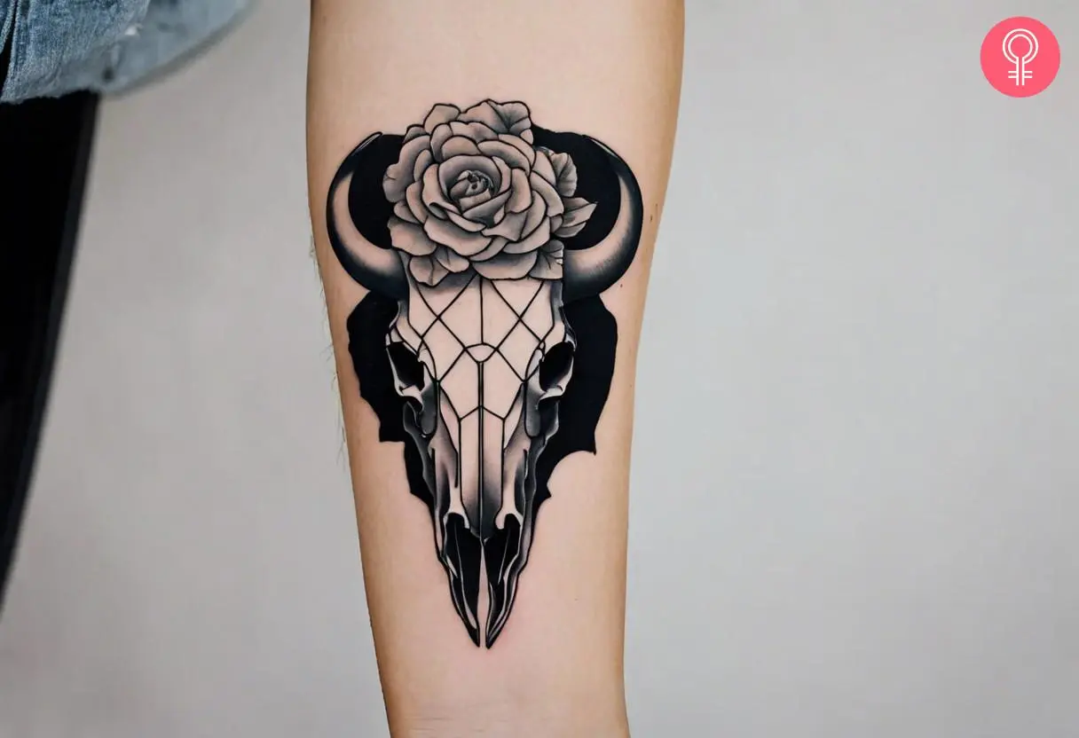 A bison skull tattoo on the forearm of a woman