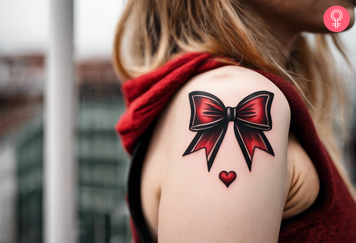 A black and red bow tattoo on a woman’s upper arm