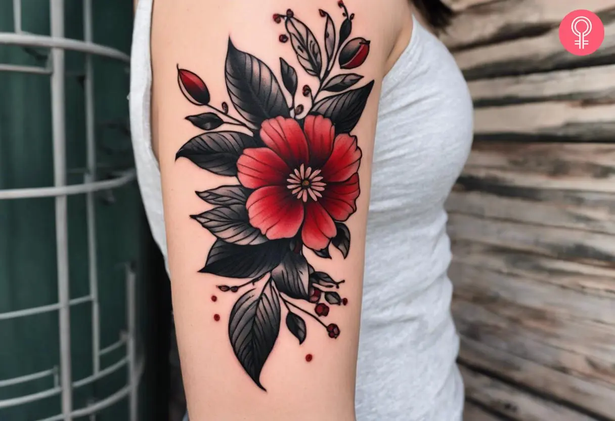 A black and red flower tattoo on a woman’s forearm