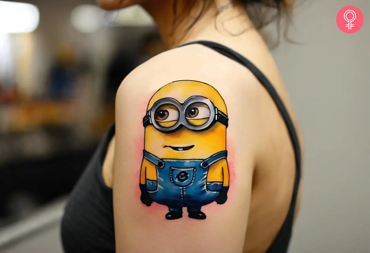 A bob minion tattoo on upper arm of a woman