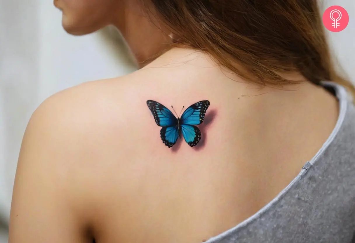 A butterfly with a shadow tattoo on a woman’s upper back