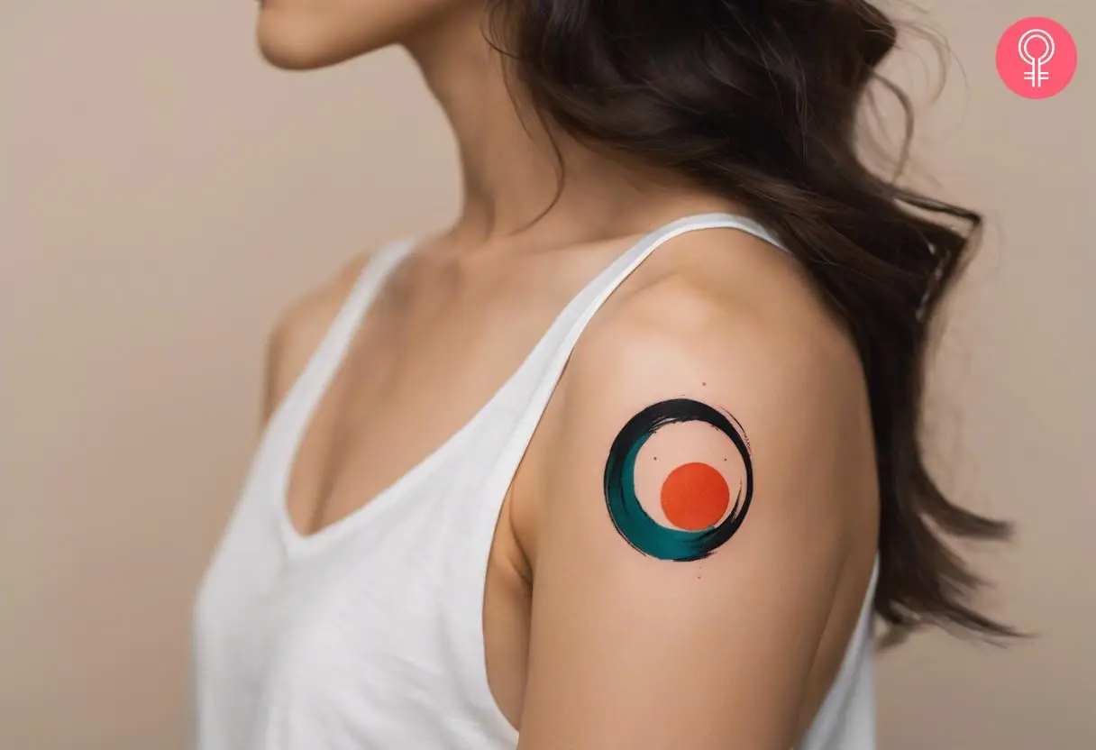 A colorful enso tattoo on a woman’s shoulder