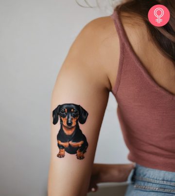 A black dog tattoo on the forearm