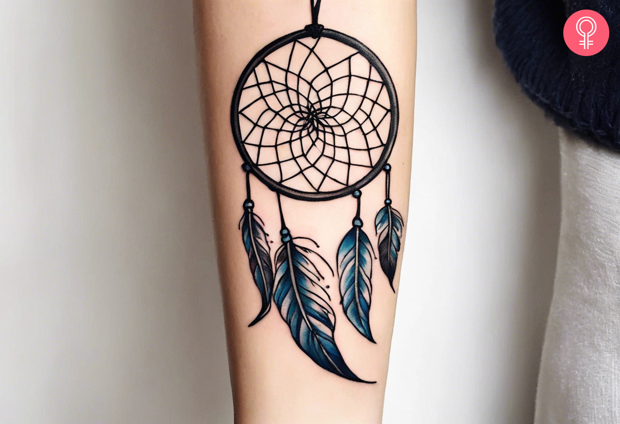 A dream catcher tattoo on the forearm