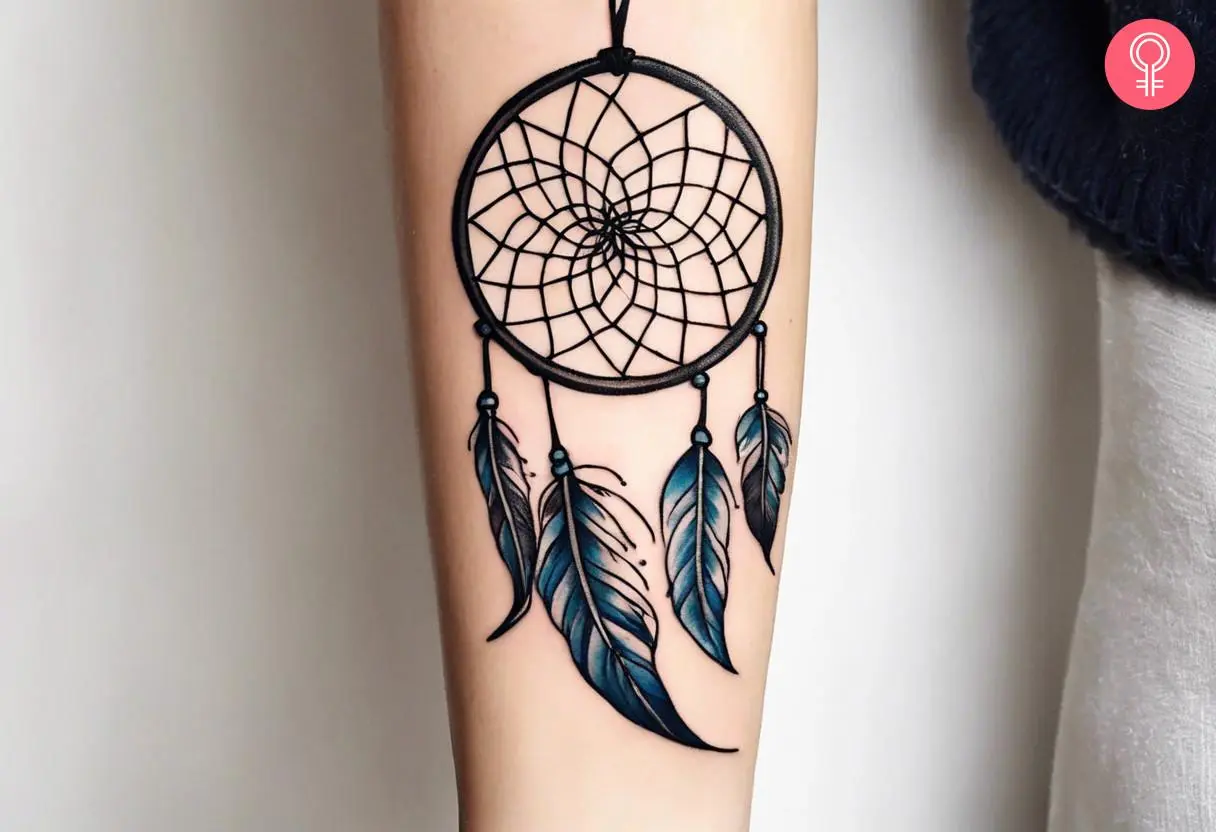 A dream catcher tattoo on the forearm