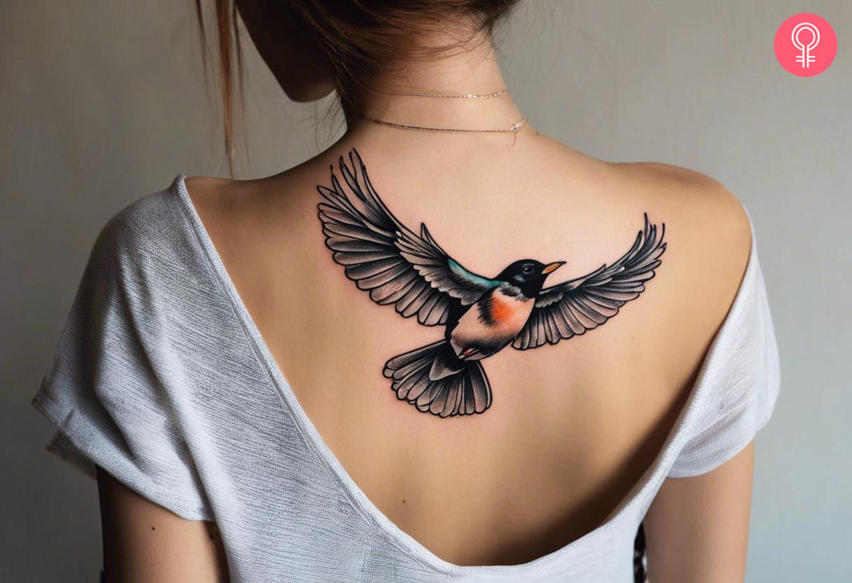 A flying robin tattoo on the upper back