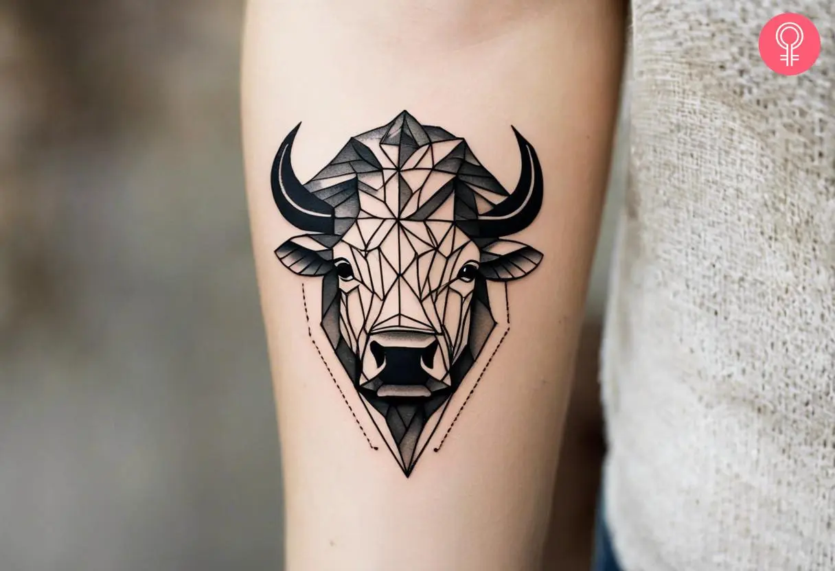 A geometric bison tattoo on the forearm of a woman