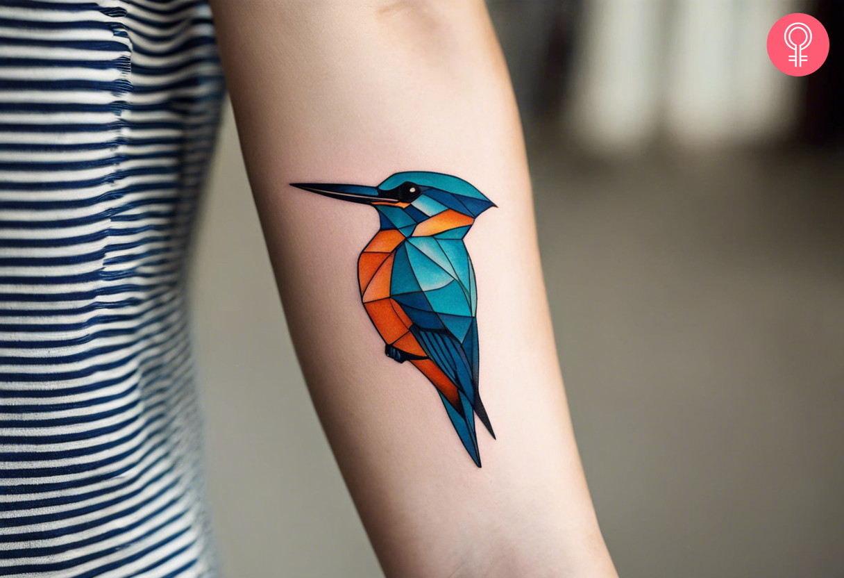 A geometric kingfisher tattoo on the forearm