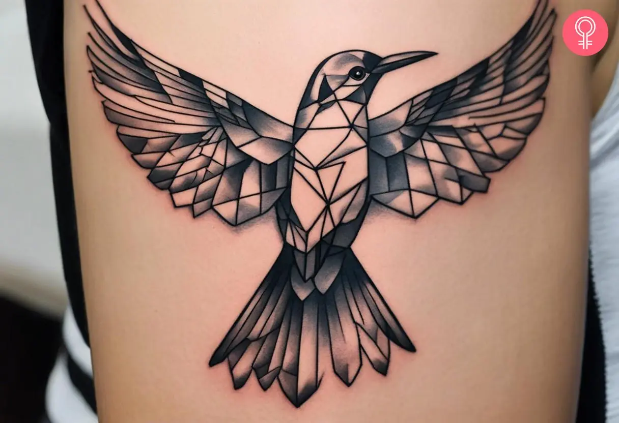 A geometric mockingbird tattoo on a woman’s upper arm