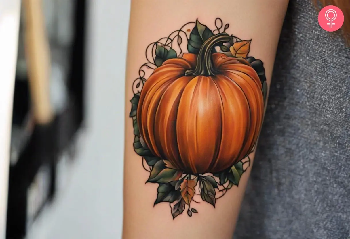 A girly pumpkin tattoo on the arm of a woman