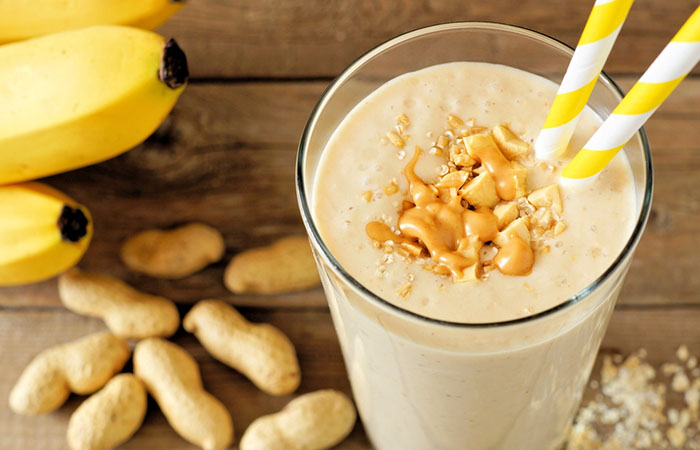 A glass of homemade oatmeal, peanut butter, and banana protein shake on the table