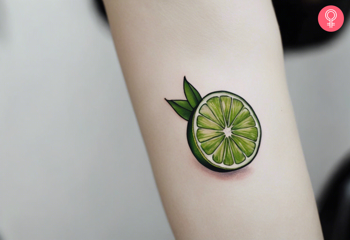 A green lime tattoo on a woman’s forearm