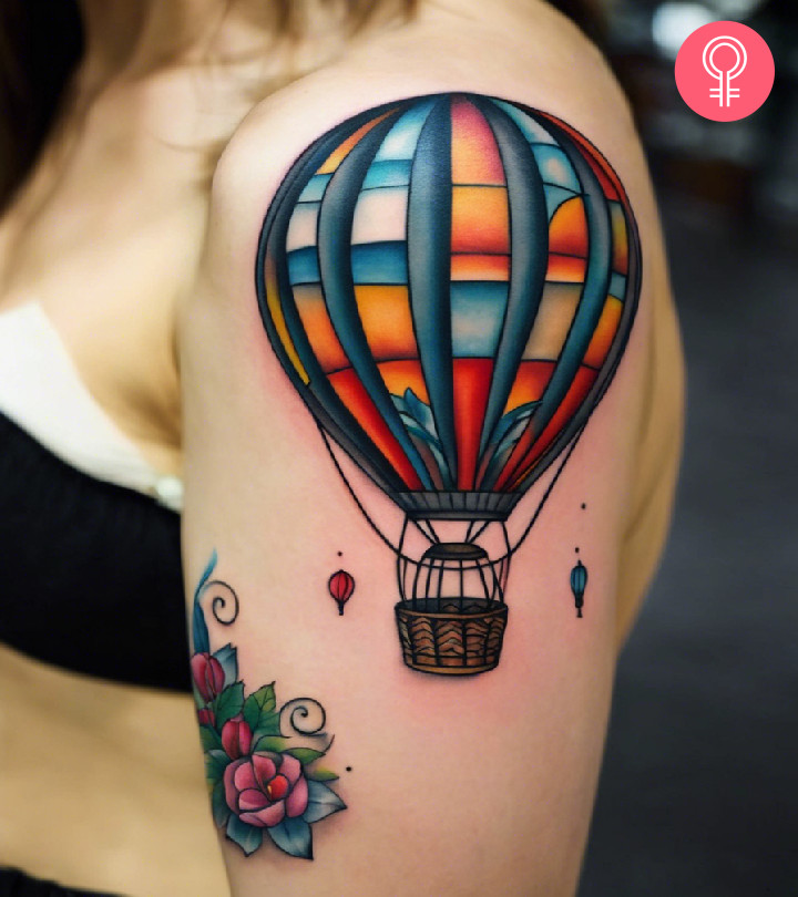 A hot air balloon tattoo on the shoulder of a woman
