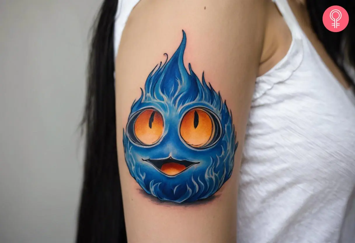 A large blue Calcifer tattoo on the upper arm