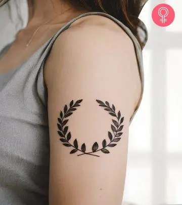 A woman with a colored bonsai tree tattoo on her upper arm