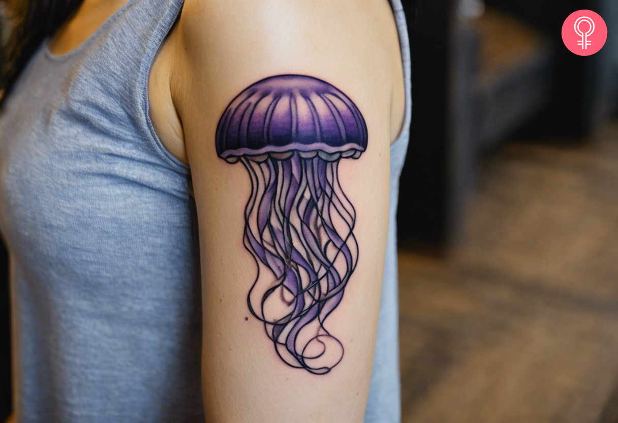 A lavender jellyfish tattoo on the upper arm of a woman