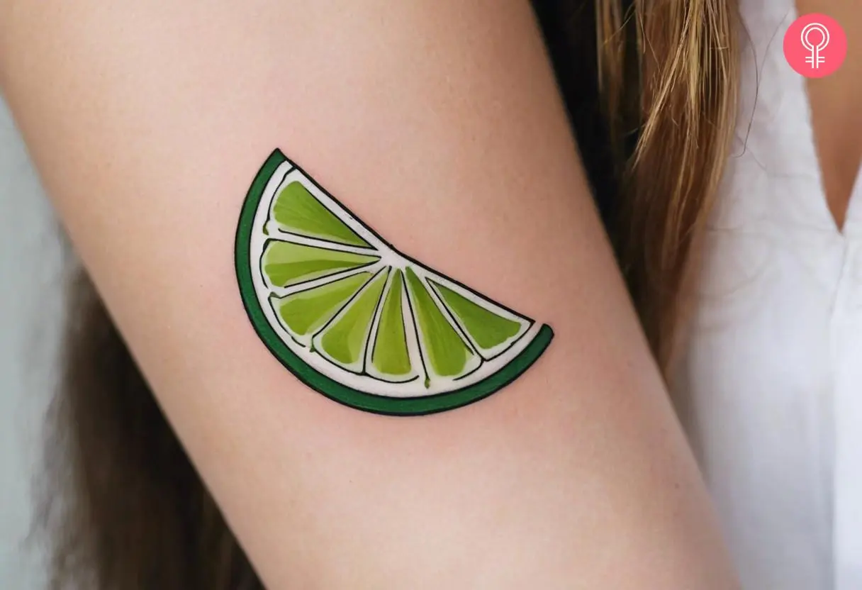 A lime slice tattoo on a woman’s upper arm