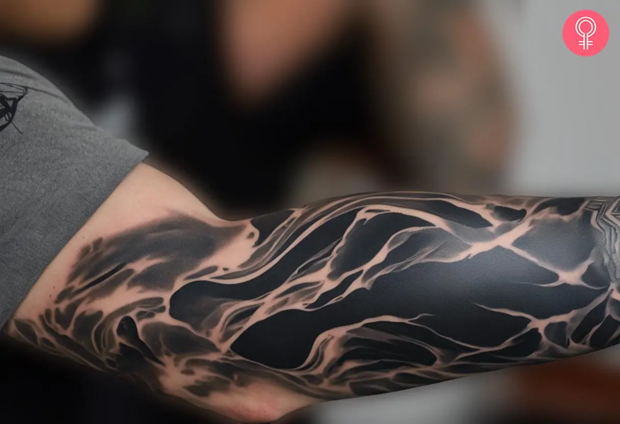 A man wearing a marble blackout tattoo on the arm