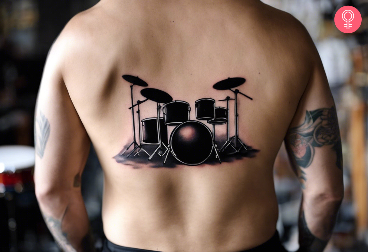 A man with a drum set tattoo on the back