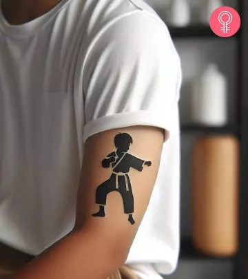 A woman with a colored bonsai tree tattoo on her upper arm