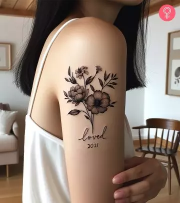 A sad girl tattoo on the upper arm