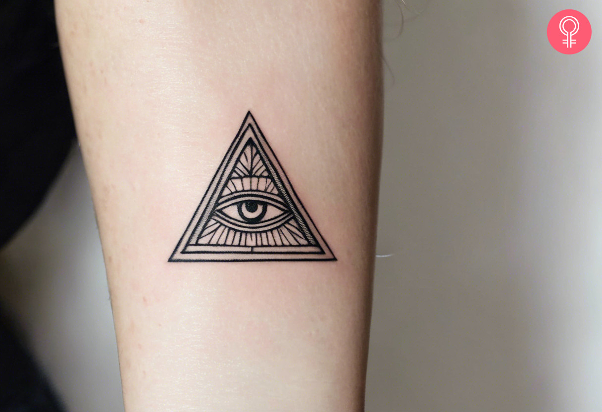 A minimalist Illuminati tattoo on the upper arm