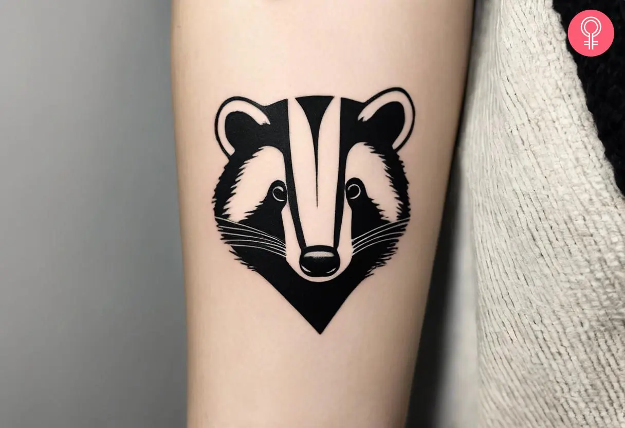 A minimalist badger tattoo on the forearm