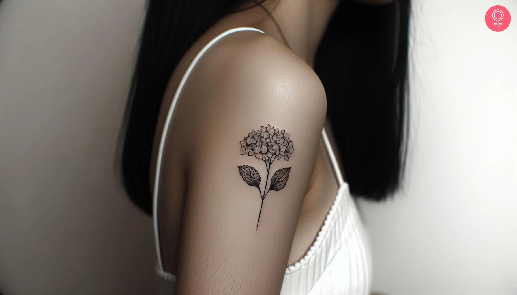 A minimalist hydrangea tattoo on the upper arm of a woman