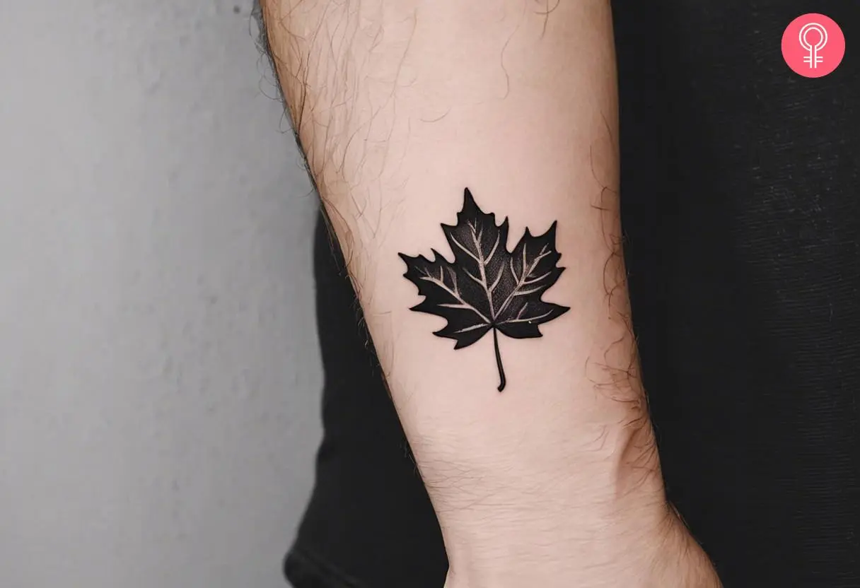 A minimalist maple leaf on a man’s forearm