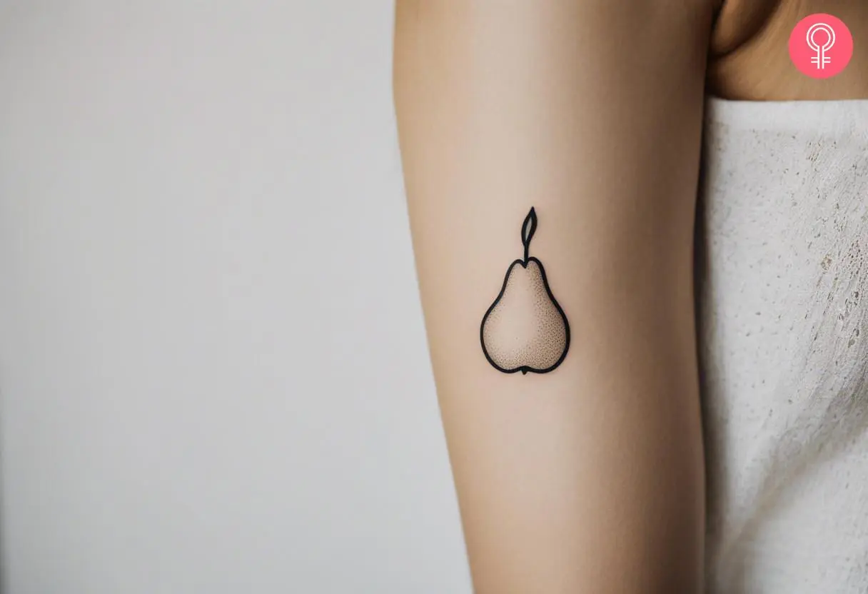 A minimalist pear tattoo on a woman’s arm