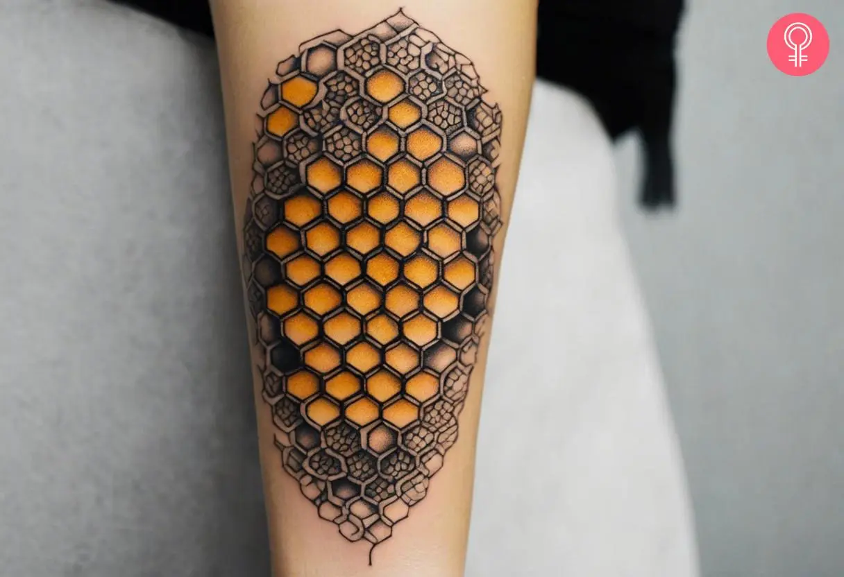 A neo-traditional beehive pattern tattoo on the arm of a woman