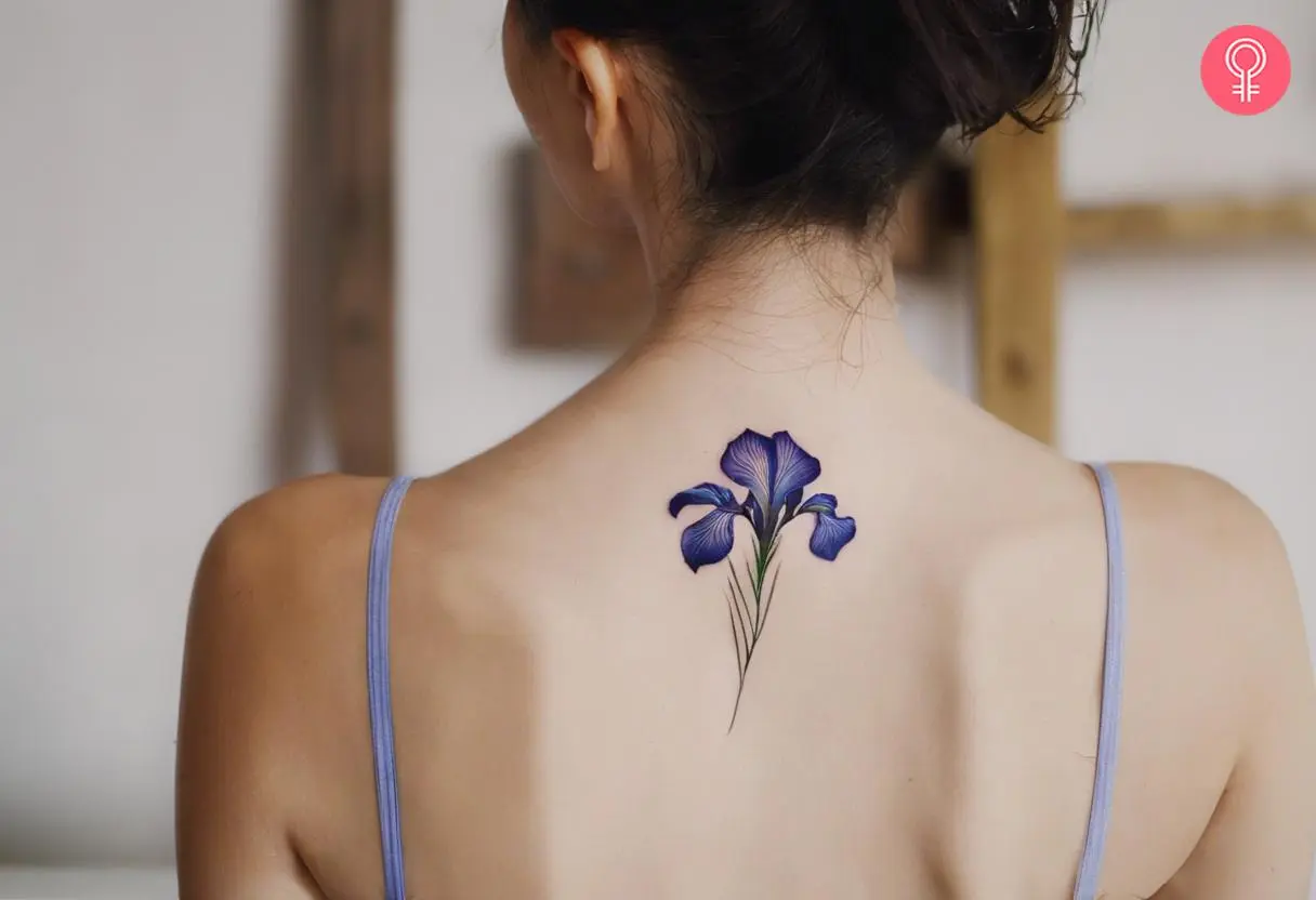 A pretty Iris bloom tattooed on a woman’s upper back