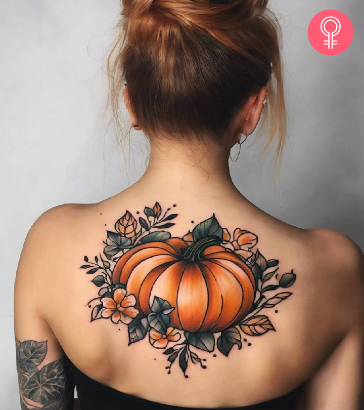 A pumpkin tattoo on the back of a woman