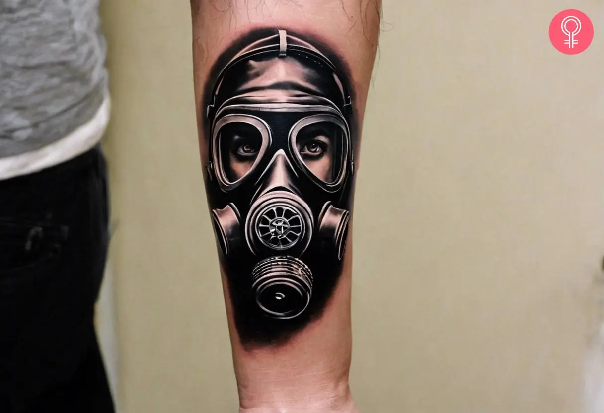 A realistic gas mask tattoo on the forearm of a man